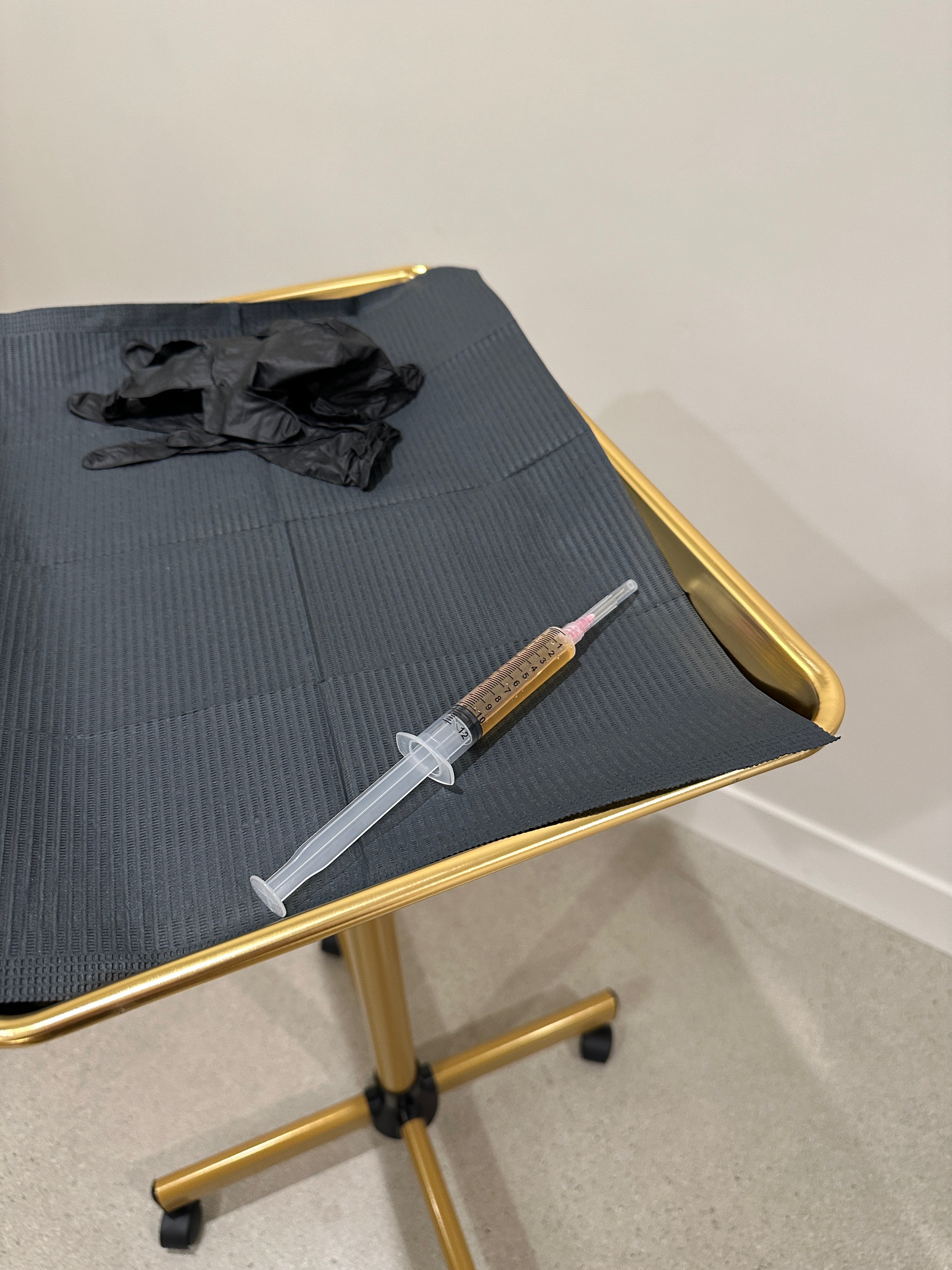 PRP Injection in Carlsbad setup with syringe and gloves on a gold medical tray.