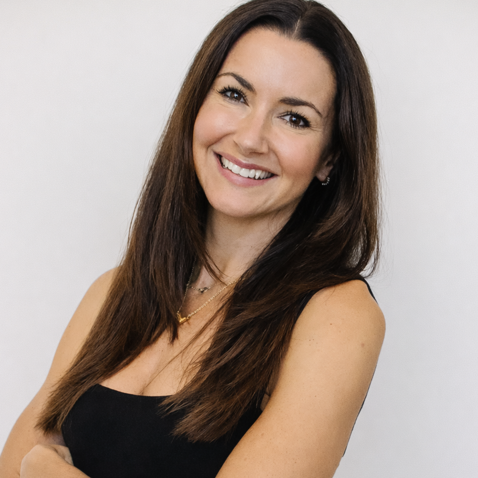 Woman with long brown hair wearing a black top against a white background